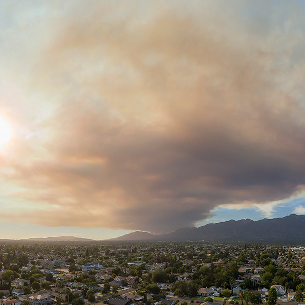 Overview of city with a large smoke cloud in the sky