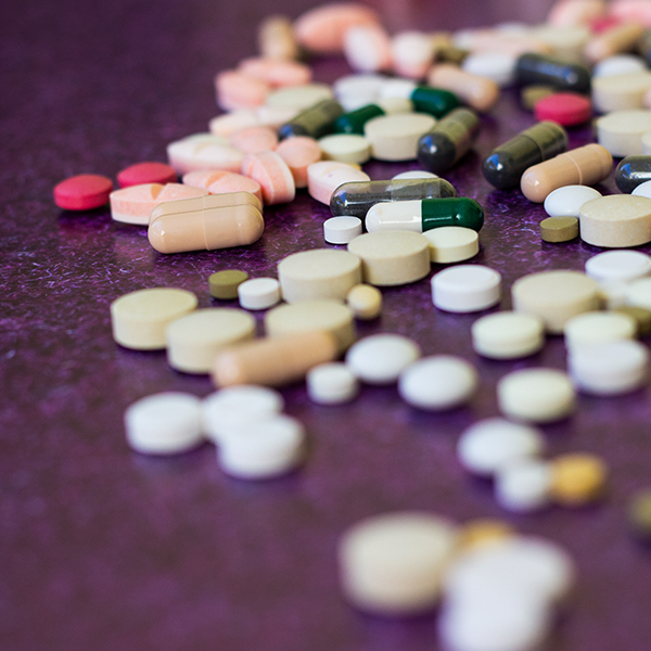 Picture of medication pills spilled out over desk